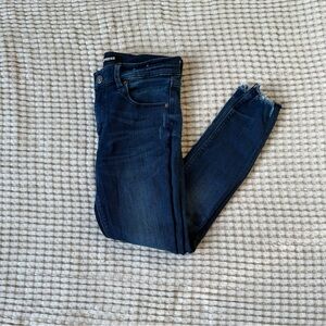 Express dark wash skinny jeans with distressed bottoms.